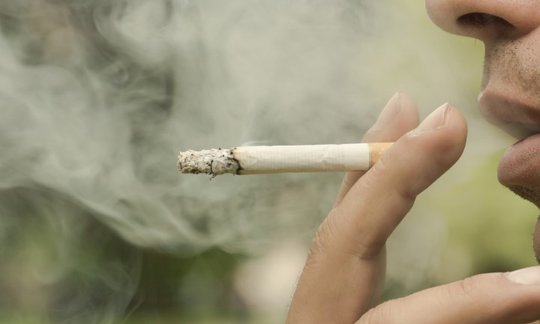 Broken cigarette and alcohol representing combined risk factors for oral cancer