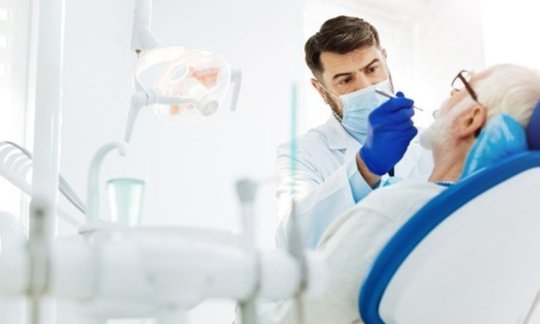 Oral surgeon reviewing an X-ray of impacted wisdom teeth before extraction