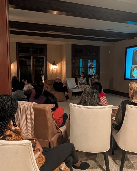 Attendees listen to a dental presentation in a living-room-style meeting space.